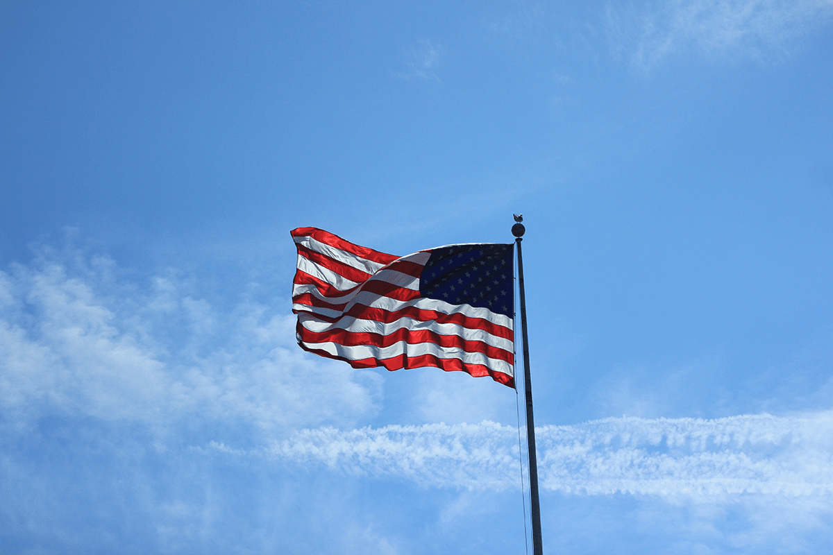 american flag waving with sky in background