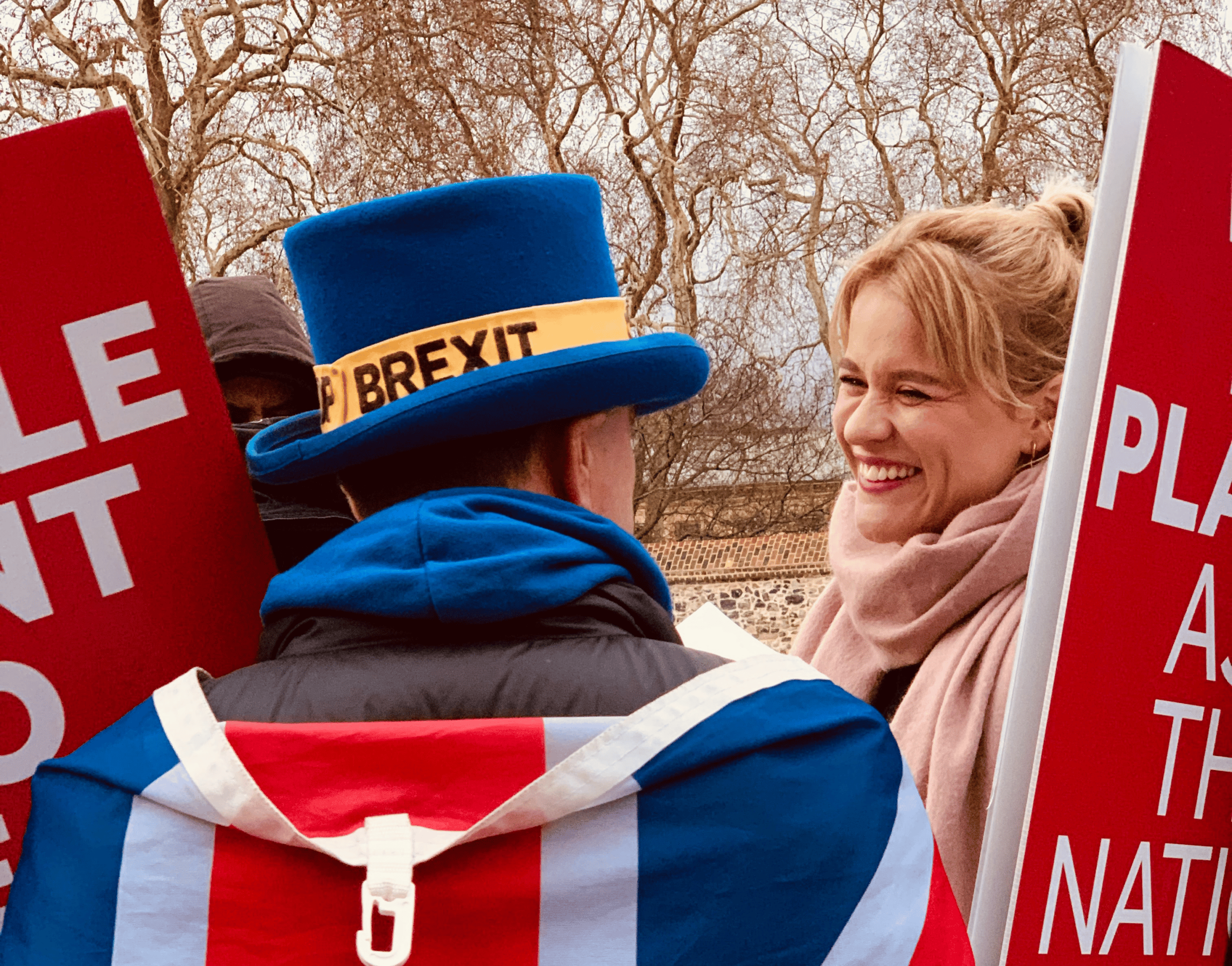 man holding signs with brexit hat on