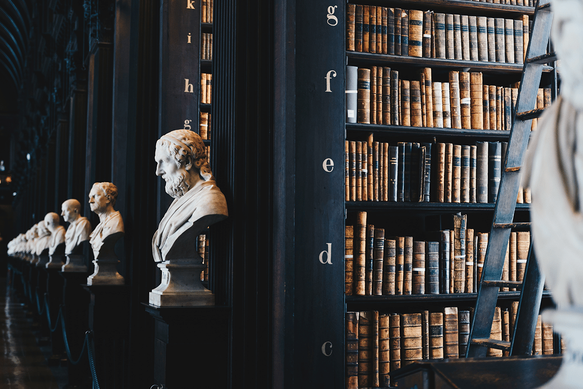 row of sculpted busts in front of bookshelves