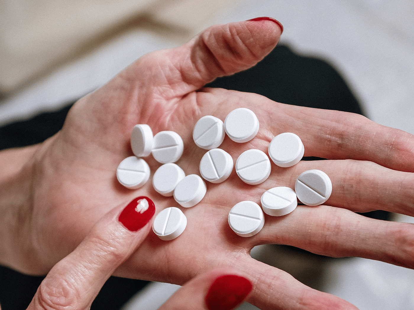 hand holding a series of white pills