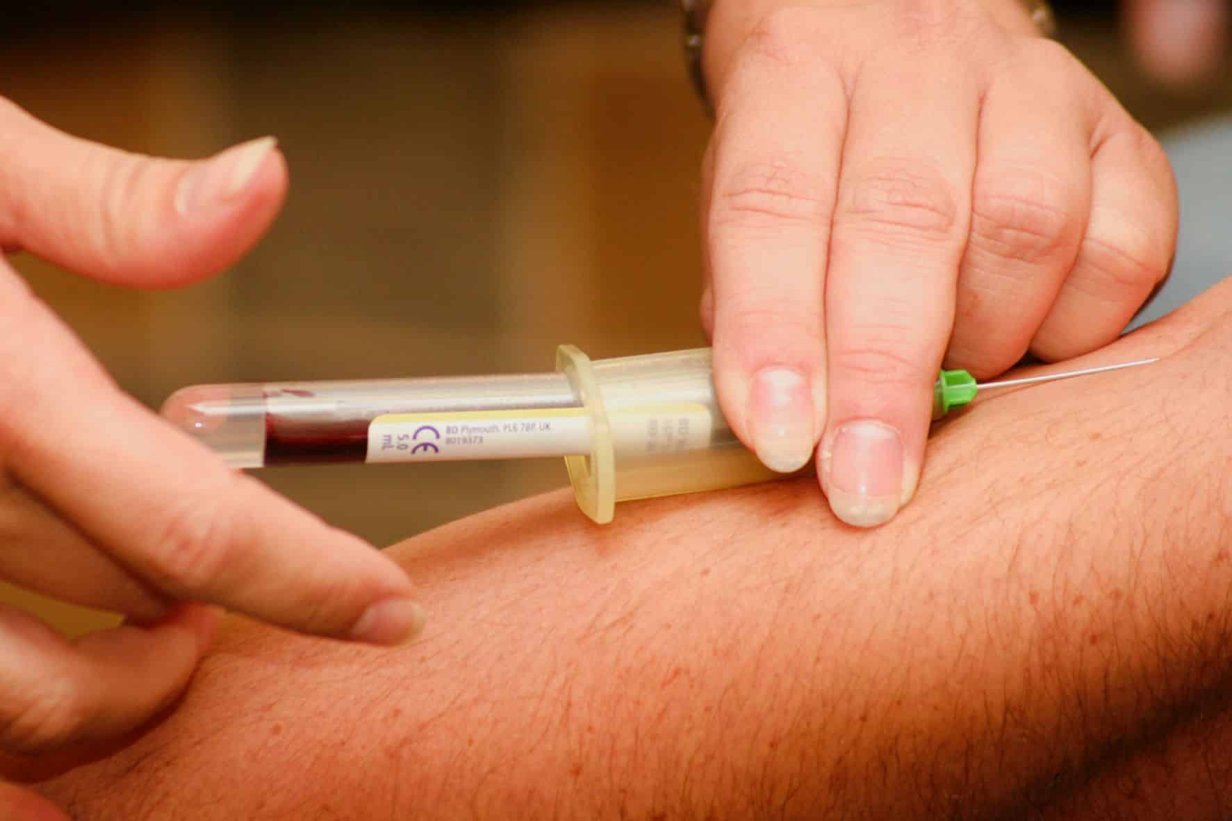 doctor drawing blood with a needle