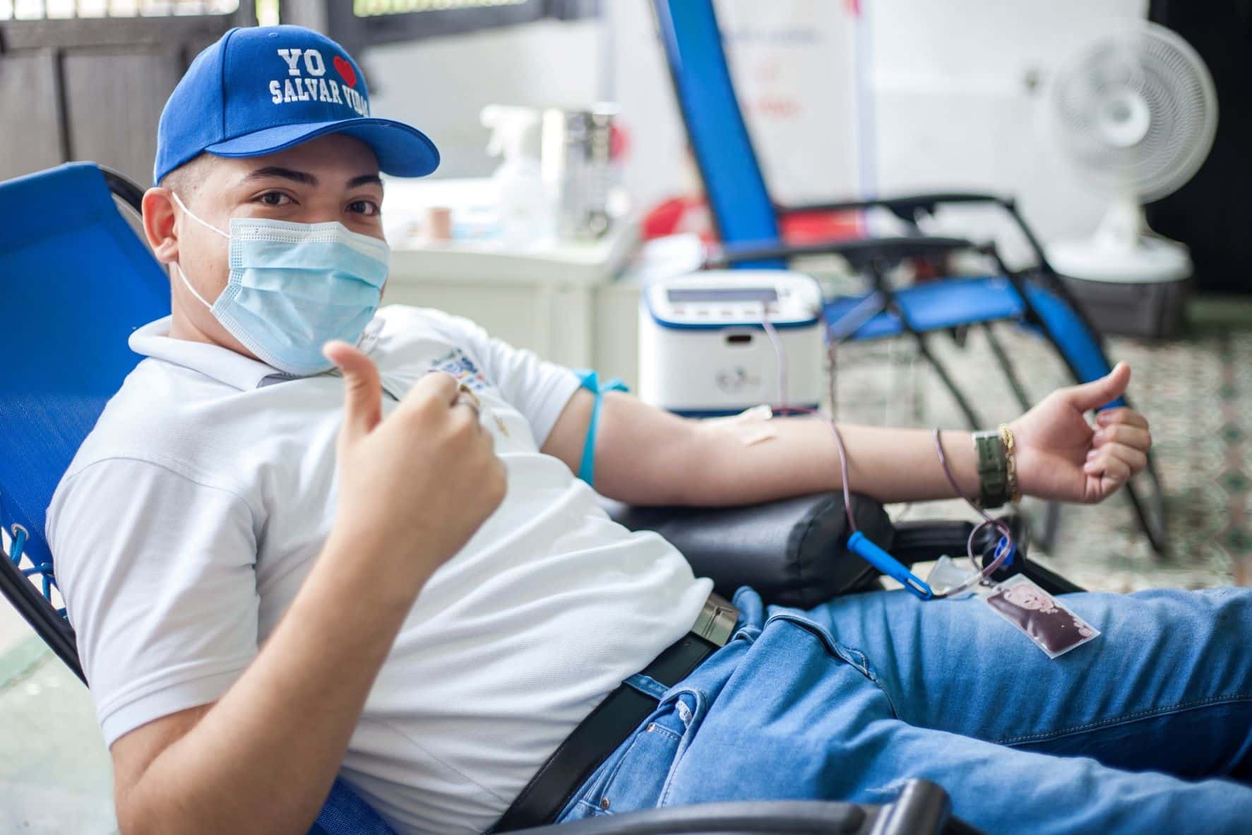 man with an iv in arm giving a thumbs up