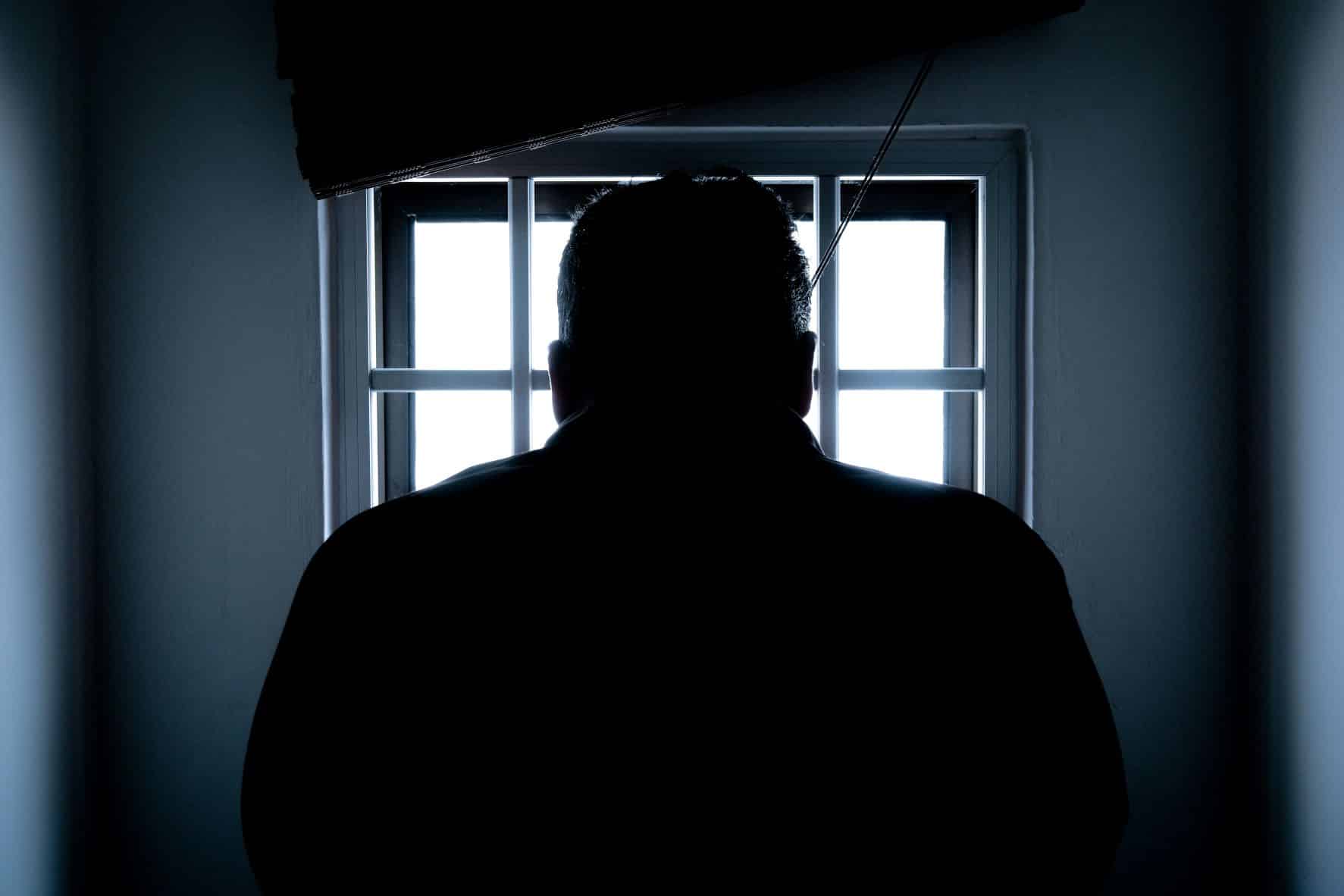 person alone in dark prison room